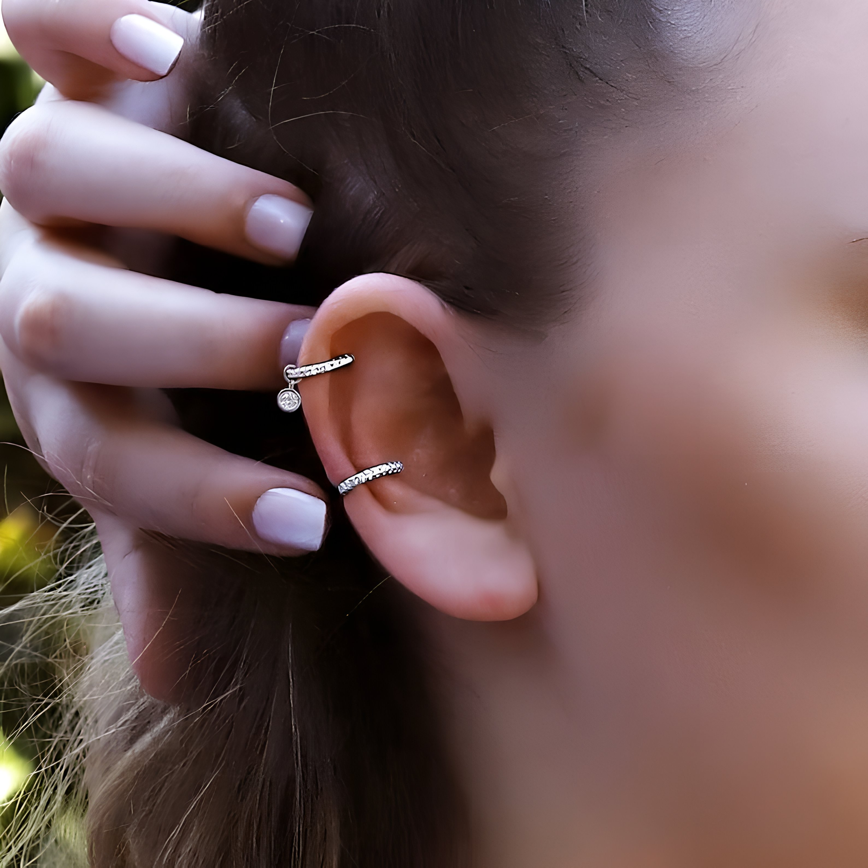 AJJ gold and silver huggie hoop earrings featuring conch, cartilage, tragus, and helix styles with pave ring details.