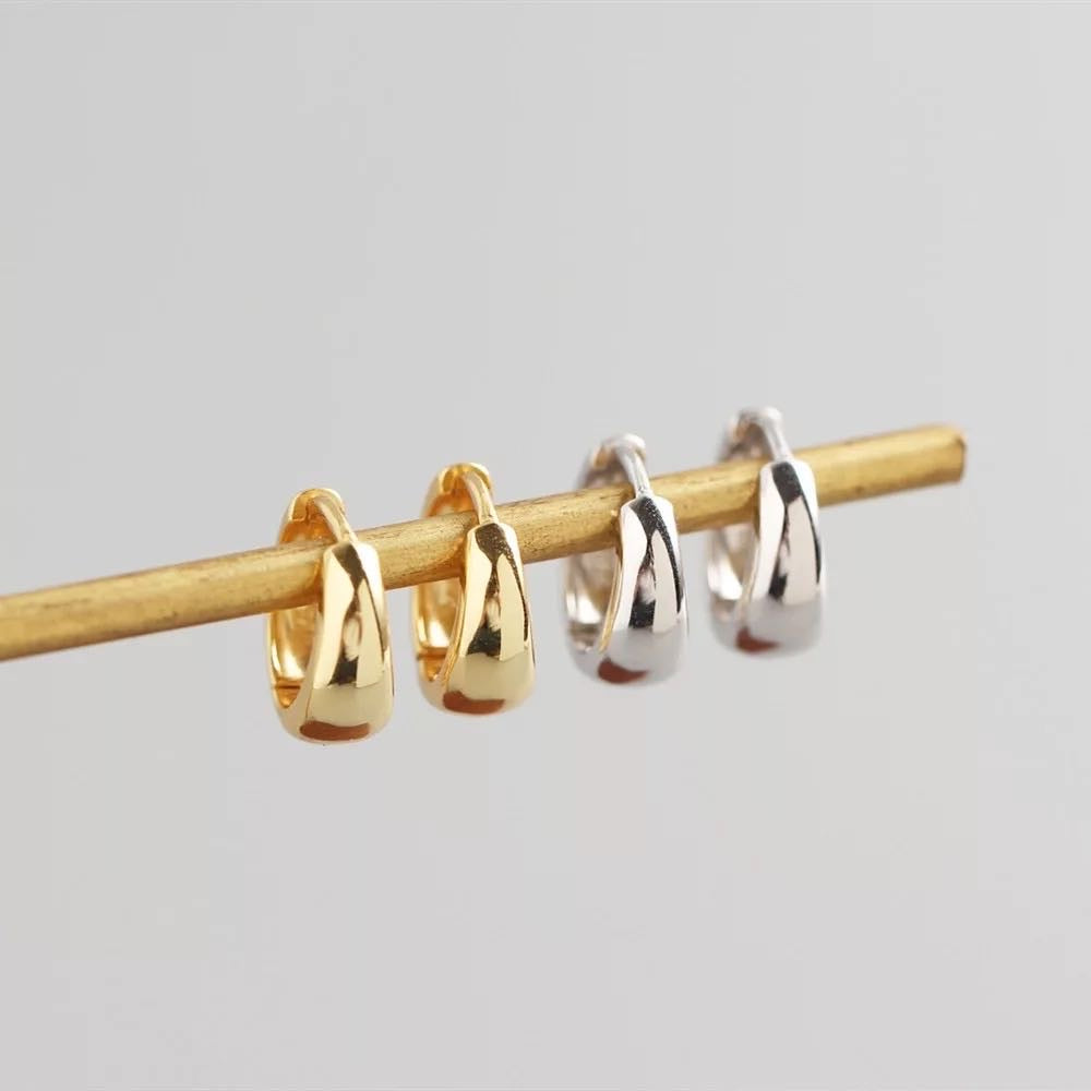 Silver and gold chunky huggie hoop earrings by AJJ featuring minimalist, small helix and sleeper hoop styles with thick, stylish design.