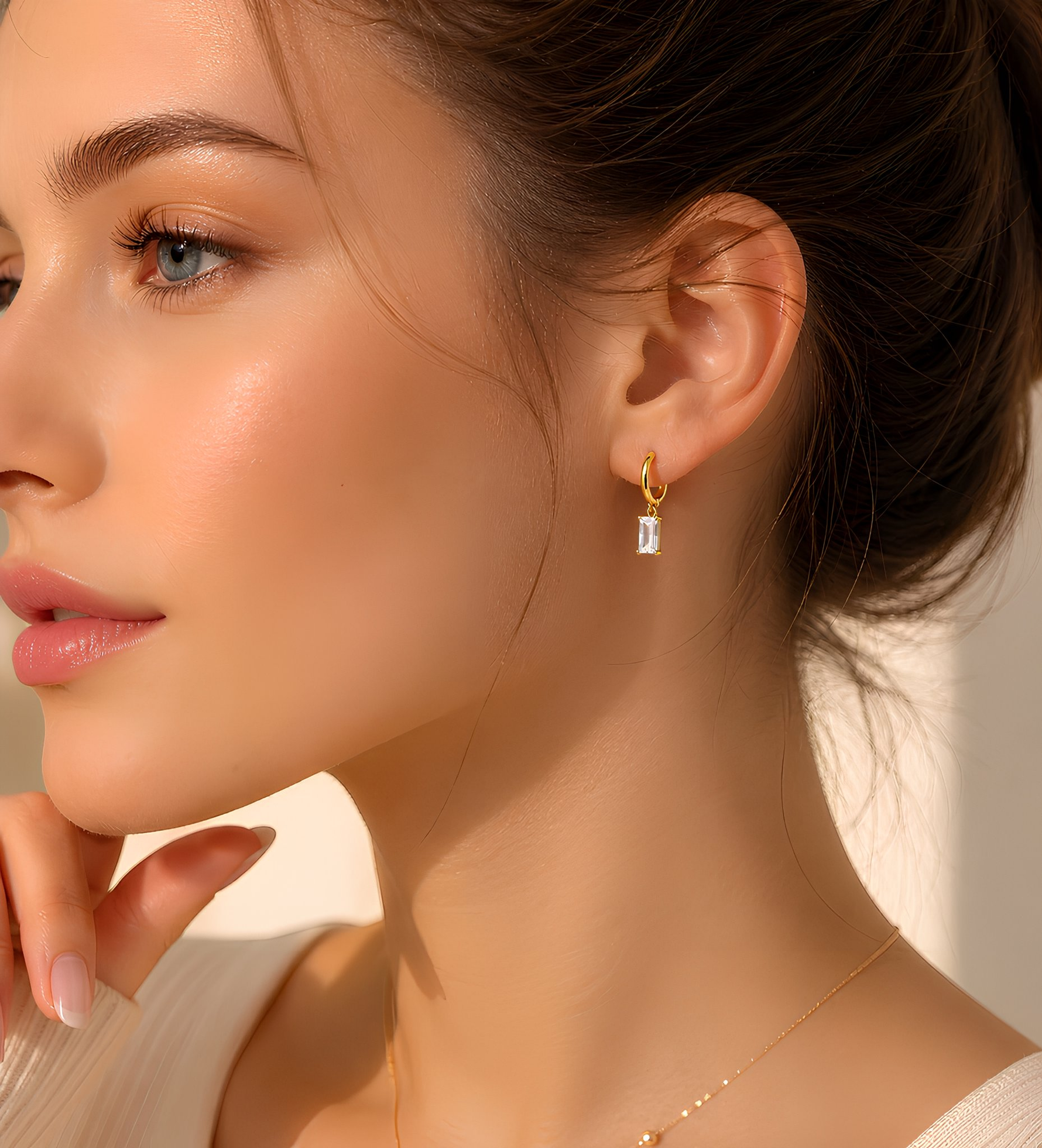 A close-up of a woman's face, focusing on her earrings and the side of her face.