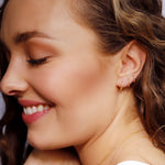 Sterling silver Aurora huggie hoop earrings by AJJ, featuring delicate, minimalist design with a sleek, polished finish.