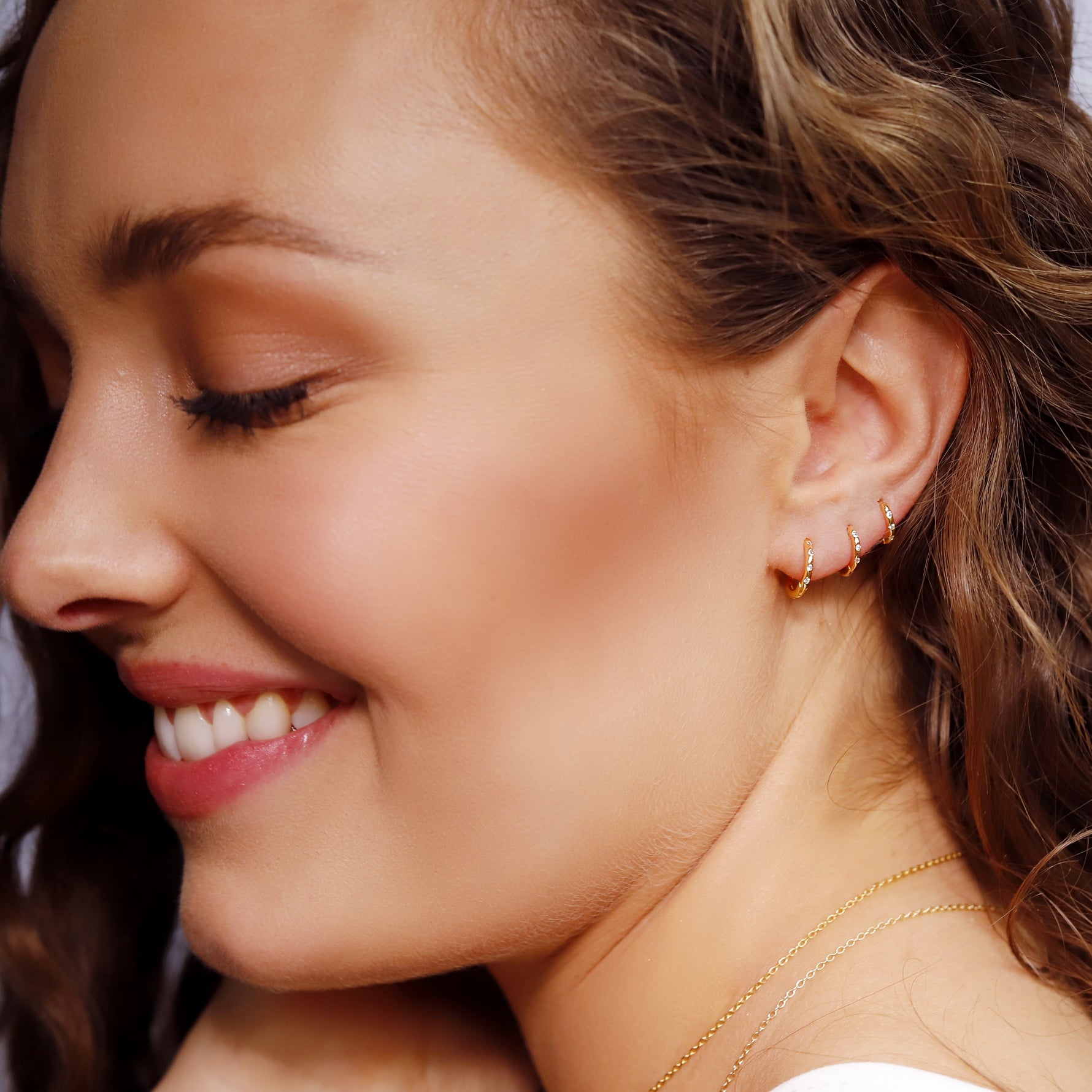 Sterling silver Aurora huggie hoop earrings by AJJ, featuring delicate, minimalist design with a sleek, polished finish.