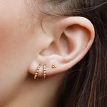 Sterling silver huggie hoop earrings with delicate bead detail, minimalist design, by AJJ, shown in full view on a white background.