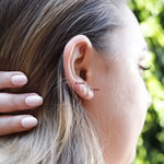 AJJ tiny huggie hoop earrings featuring dainty plain helix design, close-up of small, minimalist gold hoop earrings for everyday wear