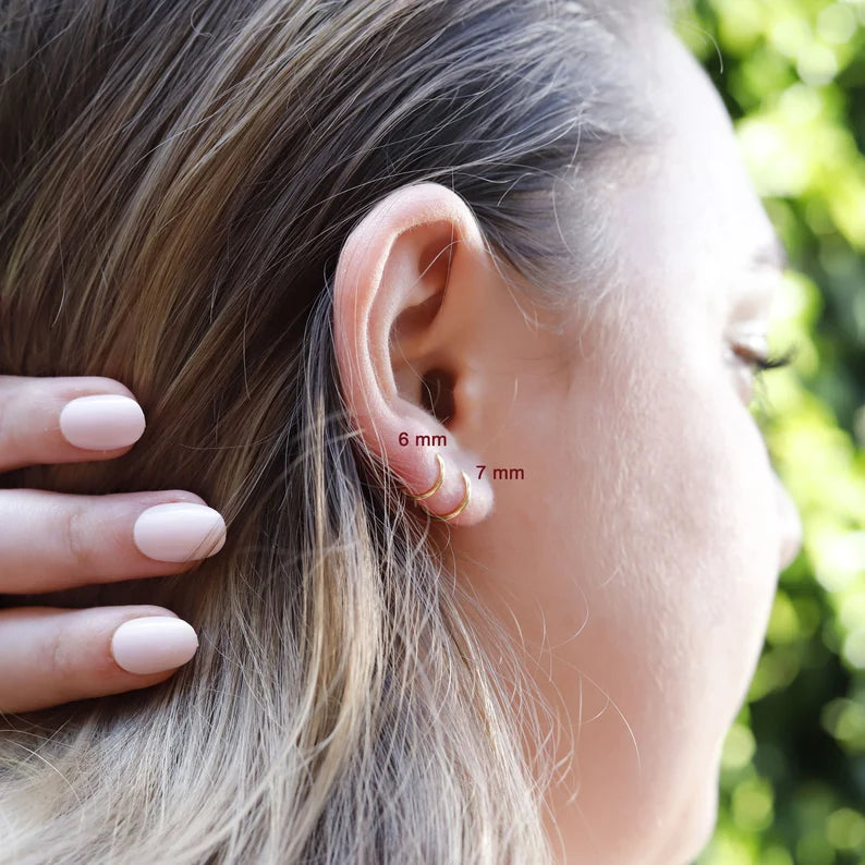 AJJ tiny huggie hoop earrings featuring dainty plain helix design, close-up of small, minimalist gold hoop earrings for everyday wear