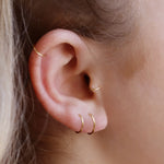 AJJ Tiny Huggie Hoop Earrings featuring plain, dainty helix design, close-up of small silver hoop earrings on a white background.