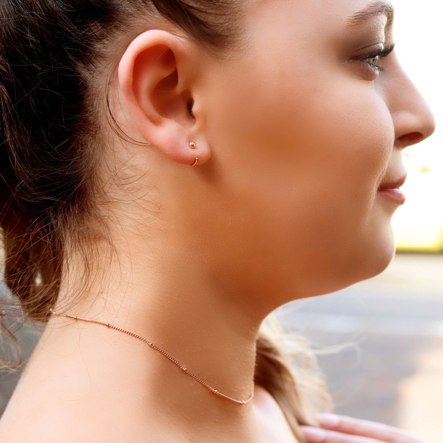 AJJ Niamh gold choker necklace featuring a delicate satellite chain with a minimalist design on a model's neck.