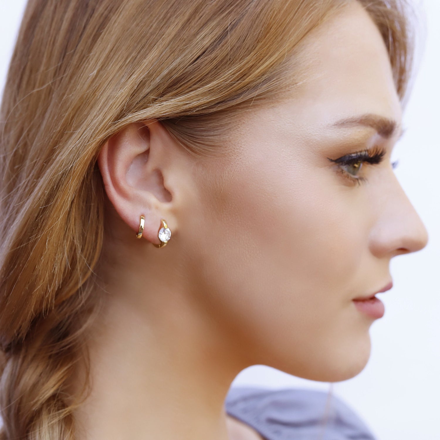 AJJ minimalist silver and gold huggie hoops, small solitaire dainty earrings with a sleek, modern design.