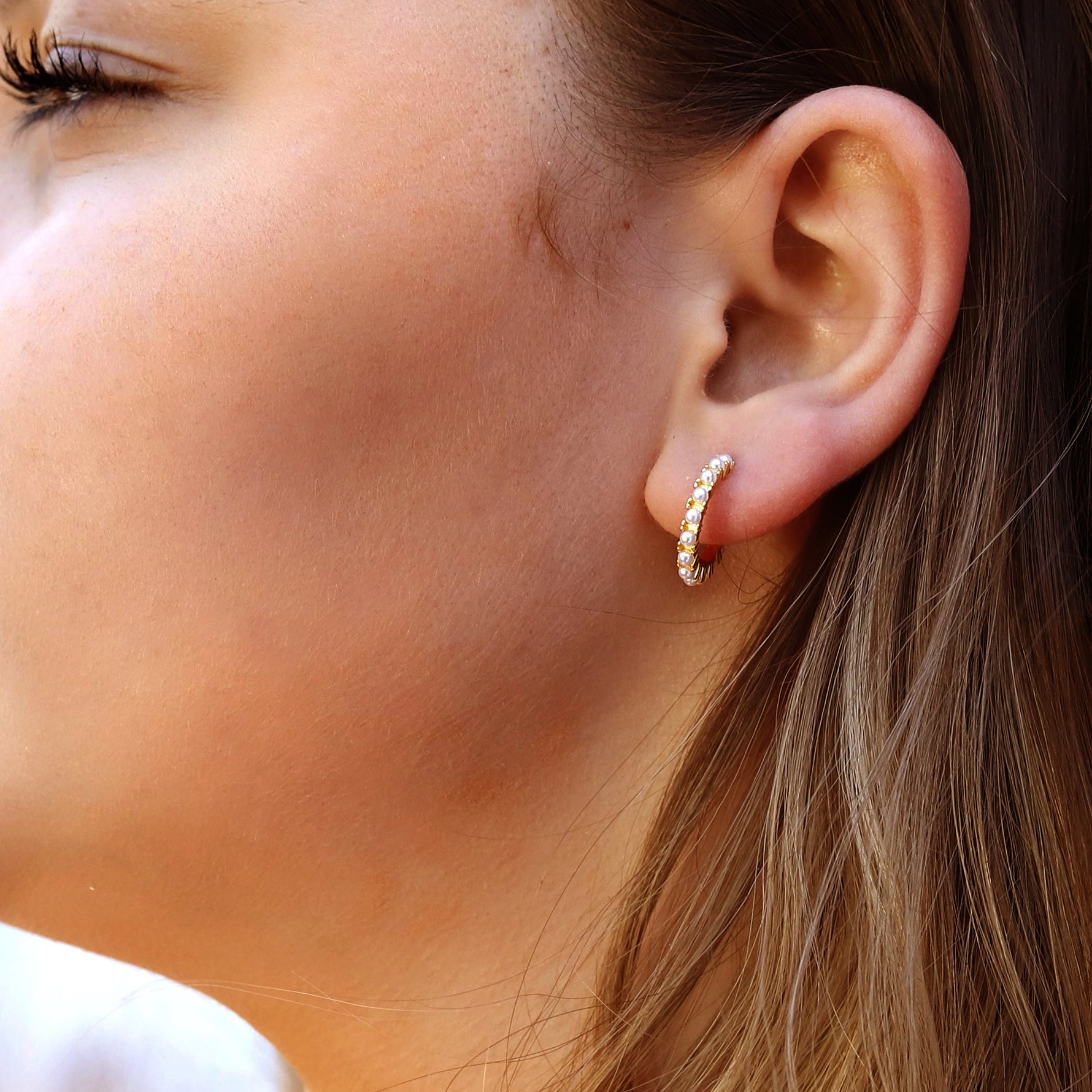 Silver AJJ minimalist huggie hoops with small pearl accents, dainty and elegant silver hoop earrings for everyday wear.