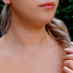 AJJ Niamh gold choker necklace featuring a delicate satellite chain design, close-up of the elegant jewelry on a model.