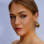AJJ minimalist silver and gold huggie hoop earrings, small dainty flower and club hoop designs on a white background.