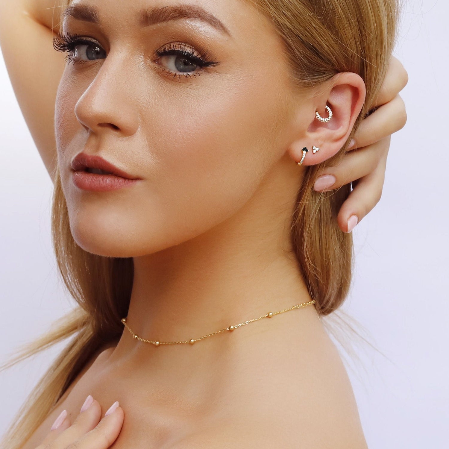 AJJ minimalist huggie hoops featuring small, dainty flower and club designs in silver and gold, perfect for elegant everyday wear.