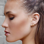 Sterling silver huggie hoop earrings by AJJ, delicate open minimalist geometric silver hoops on a white background.