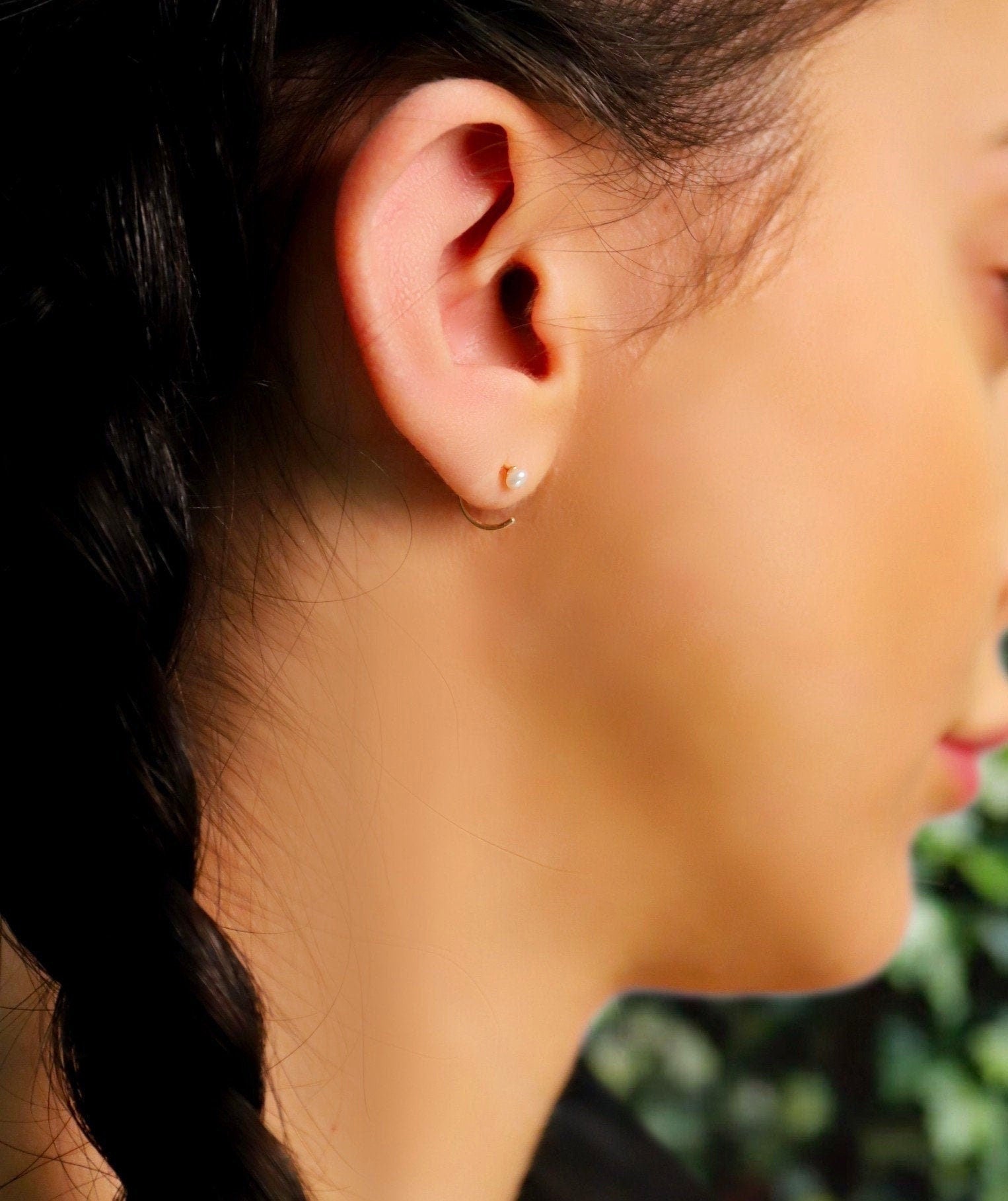 AJJ pearl huggie hoops featuring small, open silver hoop earrings with dainty pearl accents for a subtle, elegant look.