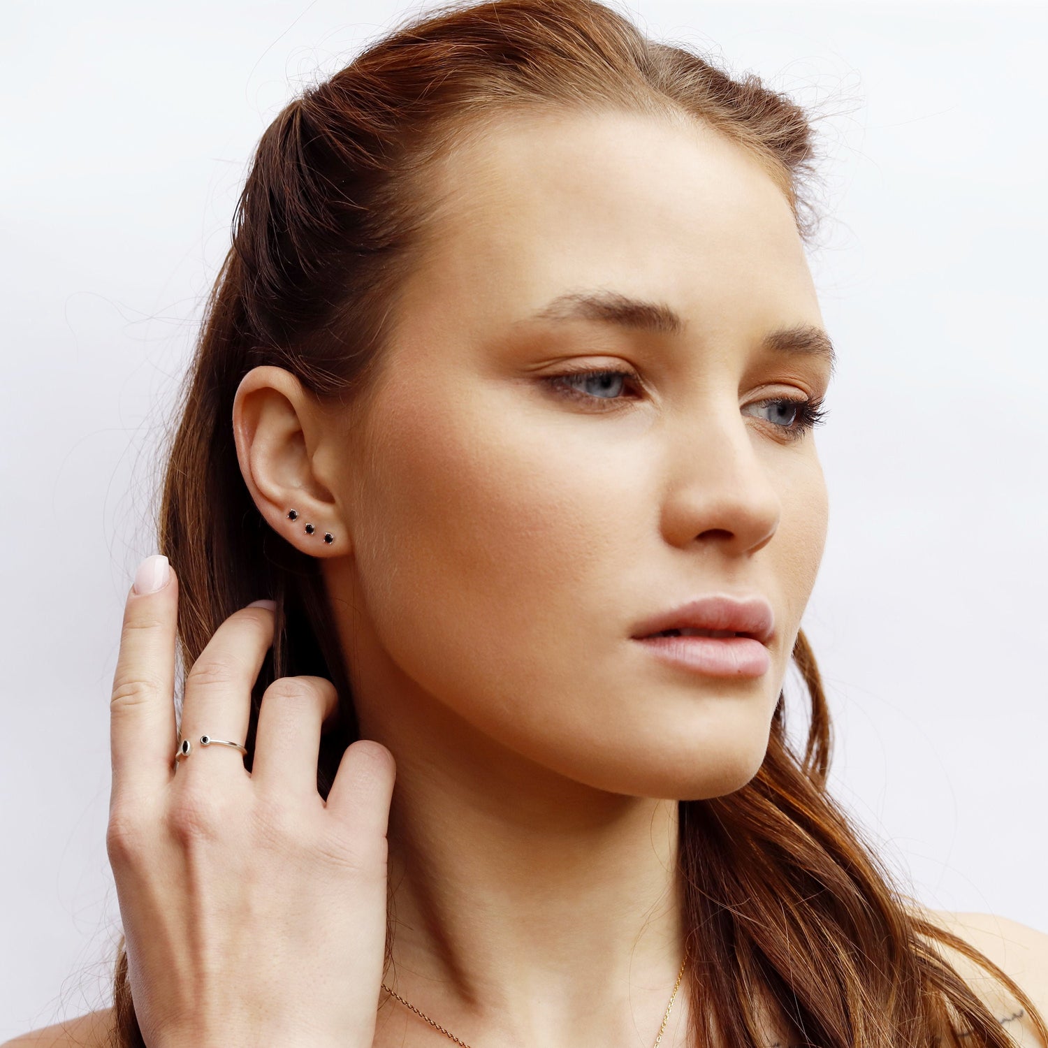 AJJ Tiny Stud Earrings set featuring round minimalist CZ studs, perfect for multiple piercings and everyday wear.