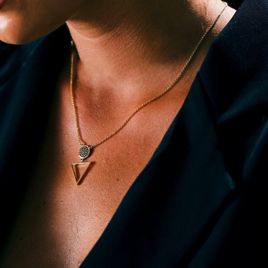 Elegant gold circle pendant necklace with crystal accents, featuring a minimalist geometric design by AJJ.