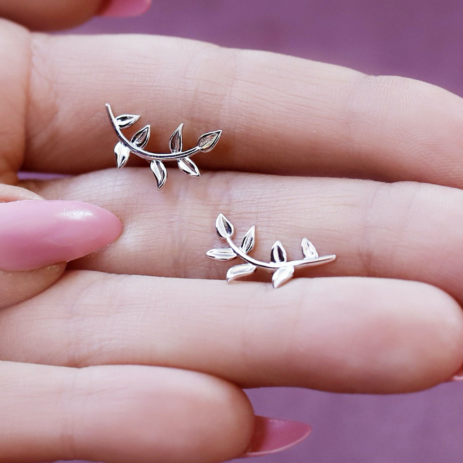 Sterling silver tiny leaves stud earrings with a modern design, featuring skinny olive leaves and sparkling details.