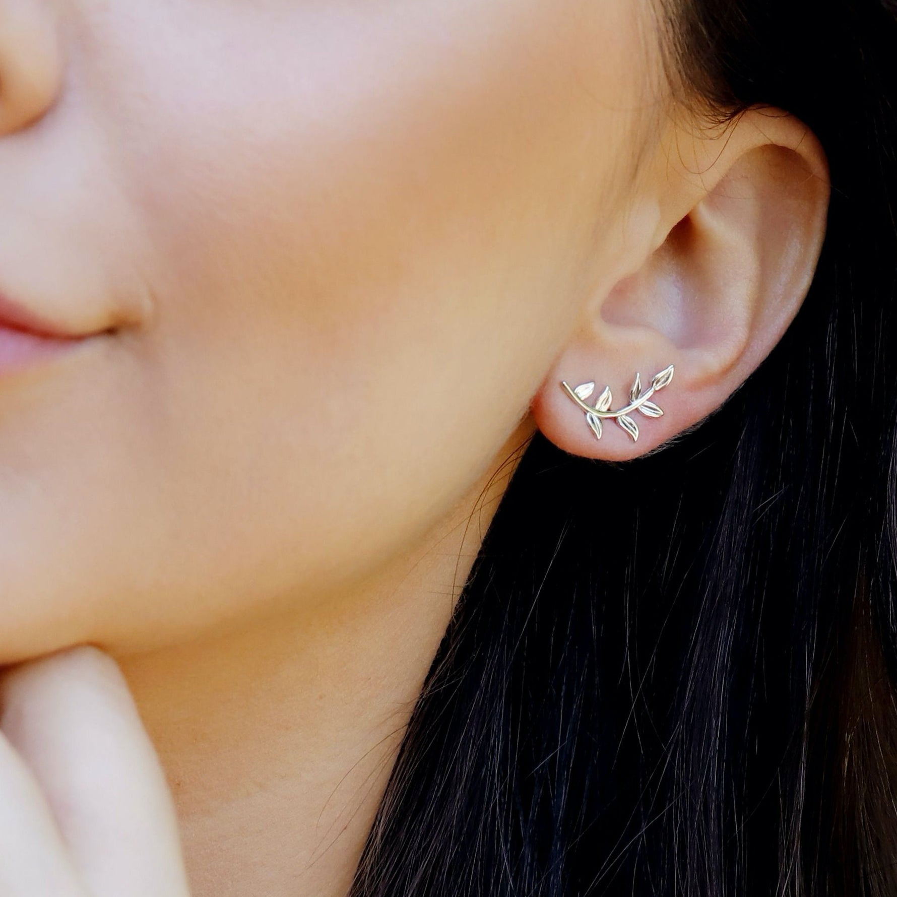 Sterling silver tiny leaves stud earrings by AJJ featuring a modern design with sparkling olive leaf details.