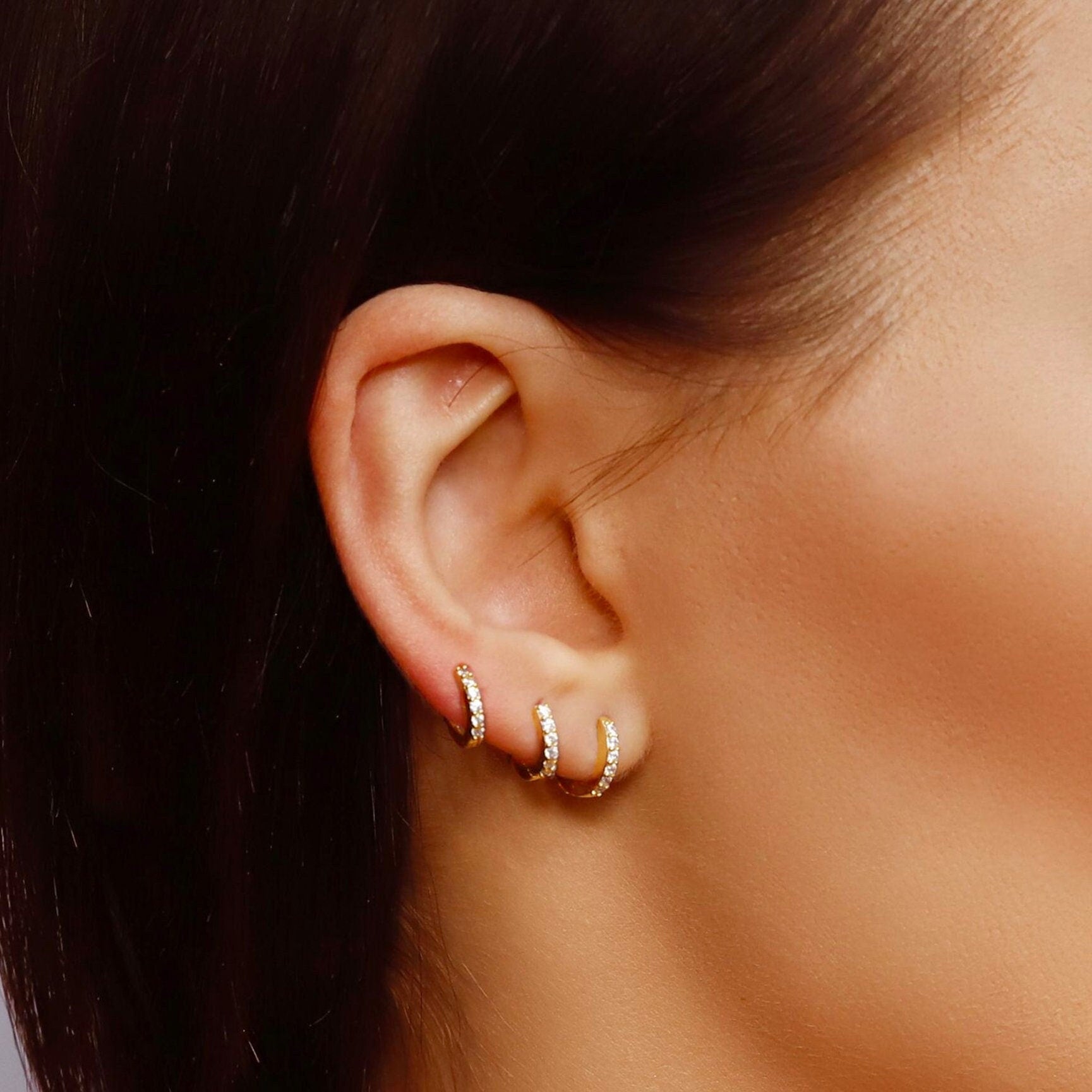 Small gold huggie hoop earrings set with cubic zirconia, minimalist sterling silver design, stylish and sparkling jewelry by AJJ.