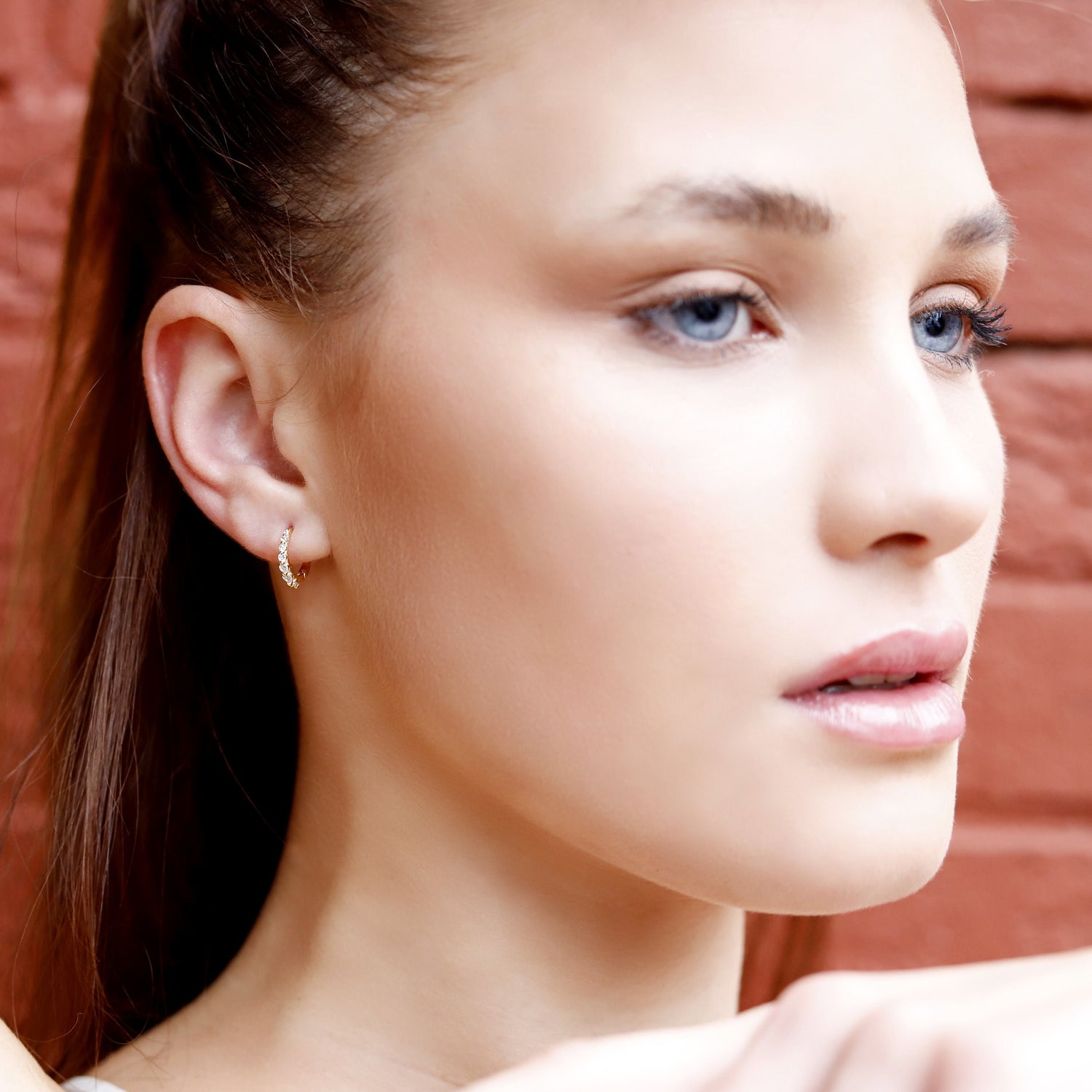 Small gold huggie hoop earrings set by AJJ featuring minimalist sterling silver hoops with pave cubic zirconia accents.