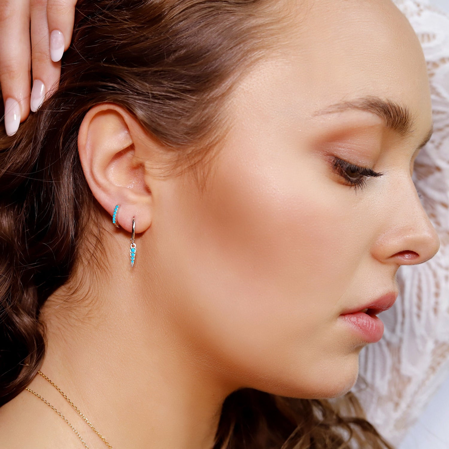 AJJ gold and turquoise huggie hoop earrings with cartilage and helix hoops, featuring silver pave rings and small tragus hoops.