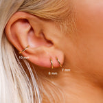 Sterling silver huggie hoop earrings by AJJ featuring delicate open geometric design, minimalist silver earrings for everyday wear.