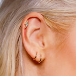 Sterling silver huggie hoop earrings by AJJ featuring delicate open geometric hoops for a minimalist and simple silver jewelry look.
