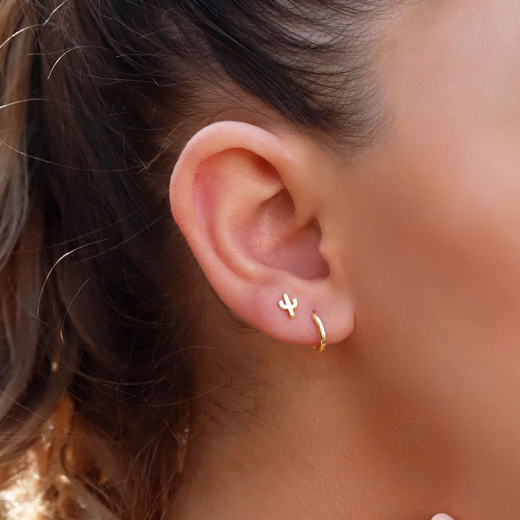 Sterling silver AJJ huggie hoop earrings with minimalist open design, close-fitting small hoops for elegant everyday wear.