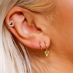 AJJ silver minimalist heart huggie hoops, small dainty silver hoop earrings, tiny helix huggie hoops on a white background.